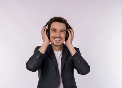 Portrait of happy young man wearing headphone and enjoy music over white background. Relax, favorite music, fun and pleasure at spare time concept.